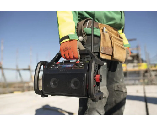 Stavebný robotník nesie staveniskové rádio