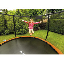 Dievča skáče na záhradnej trampolíne so sieťou