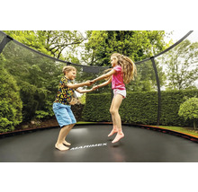 Dve deti skáču na záhradnej trampolíne so sieťou