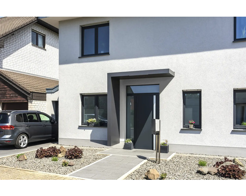 Vchodová strieška Gutta BS Plus 200 RAL 7016 200x90 cm vrátane ľavého bočného dielu, odtok vody v bočnom diele Moderný rodinný dom so vstupom, oknami a dláždenou záhradnou cestou