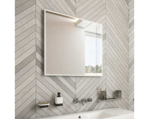 Kúpeľňa so zrkadlovou skrinkou, umývadlom a batériou pred stenou so vzorom rybej kosti