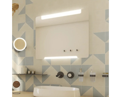 Svetlá kúpeľňa s osvetlenou zrkadlovou skrinkou, umývadlom a doplnkami.