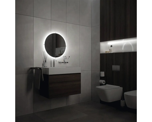 Moderná kúpeľňa s osvetleným zrkadlom, umývadlom a toaletou.