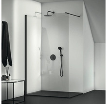 Sprchovací kút v úrovni podlahy so sklenenou stenou a čiernymi armatúrami v kúpeľni.