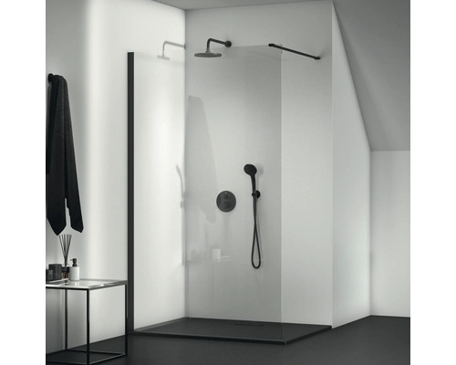 Sprchovací kút v úrovni podlahy so sklenenou stenou a čiernymi armatúrami v kúpeľni.