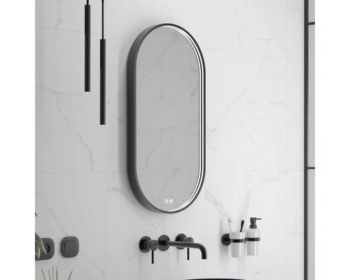 Moderná kúpeľňa s podlhovastým zrkadlom, nástennou batériou a minimalistickým osvetlením