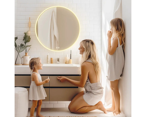 Kúpeľňa s okrúhlym osvetleným zrkadlom nad umývadlom a rodinou