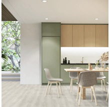 Svetlá kuchyňa s jedálenským stolom a stoličkami, kombinovaná s kuchynským nábytkom v drevenom vzhľade a zelenej farbe.