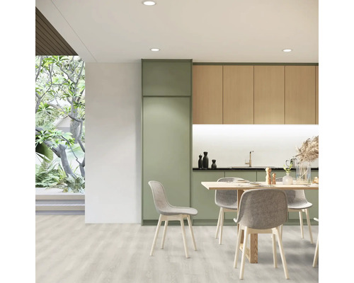 Svetlá kuchyňa s jedálenským stolom a stoličkami, kombinovaná s kuchynským nábytkom v drevenom vzhľade a zelenej farbe.