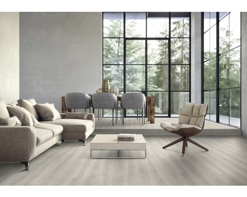 Svetlá obývacia izba s pohovkou, stoličkami, stolom a veľkým oknom s výhľadom na stromy.