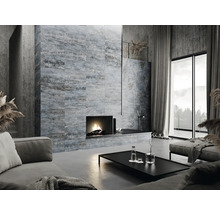 Obývacia izba s krbom, pohovkou, stolom a obloženou stenou s betónovým vzhľadom.