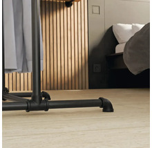 Detail vešiaka na šaty s industriálnym dizajnom v spálni.