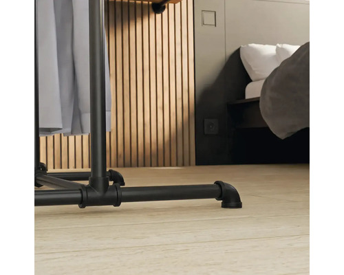 Detail vešiaka na šaty s industriálnym dizajnom v spálni.