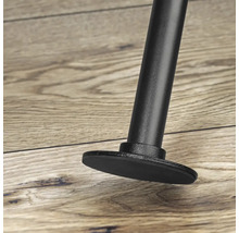 Detailný pohľad na kovovú nohu nábytku s ochranou podlahy na drevenej podlahe.