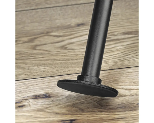 Detailný pohľad na kovovú nohu nábytku s ochranou podlahy na drevenej podlahe.