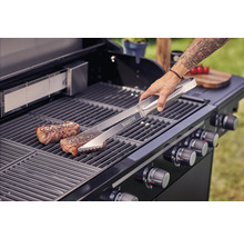 Grilovacia scéna s grilovacími kliešťami, steakom a plynovým grilom