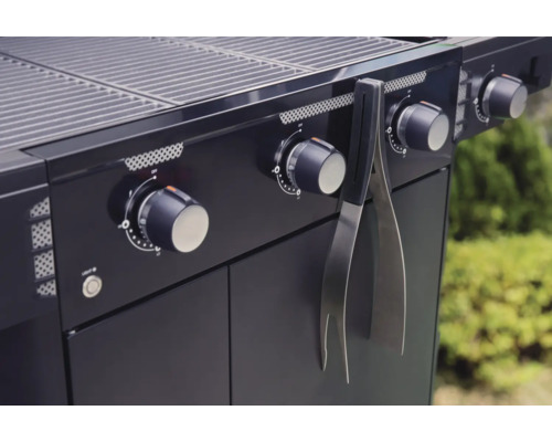Detail plynového grilu s grilovacími kliešťami