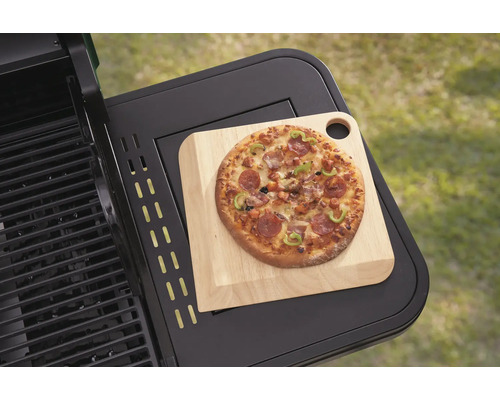 Pizza na drevenej doske na grilovacom stole