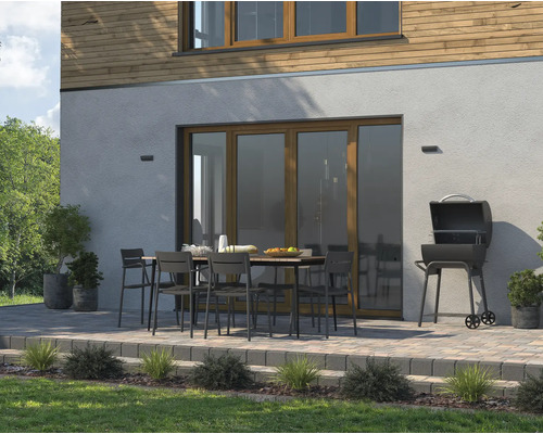 Vonkajšia scéna s grilom, záhradným stolom a stoličkami na terase pred domom