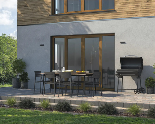 Vonkajšie posedenie so záhradným stolom, stoličkami a grilom na dláždenej terase