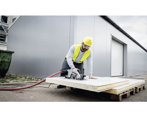 Remeselník reže izolačnú dosku pílou Metabo na stavenisku