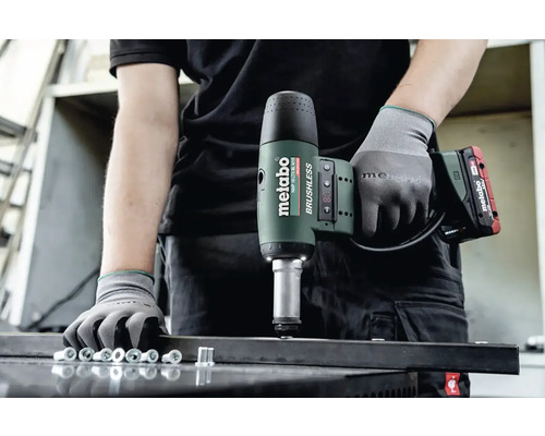 Muž s akumulátorovým nitovacím nástrojom Metabo nituje nity do kovového profilu.