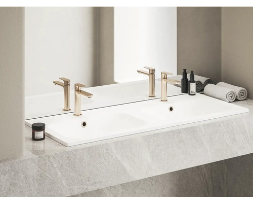 Dvojité umývadlo s batériami, kozmetickými produktmi a uterákmi v kúpeľni.