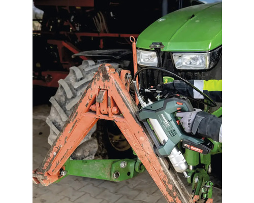 Akumulátorový mazací lis používaný na traktore