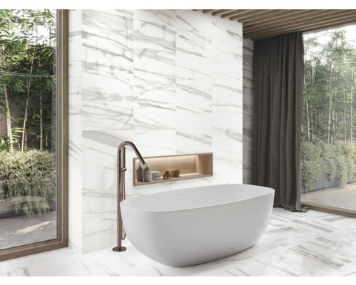 Moderná kúpeľňa s voľne stojacou vaňou, batériou a mramorovými obkladmi.
