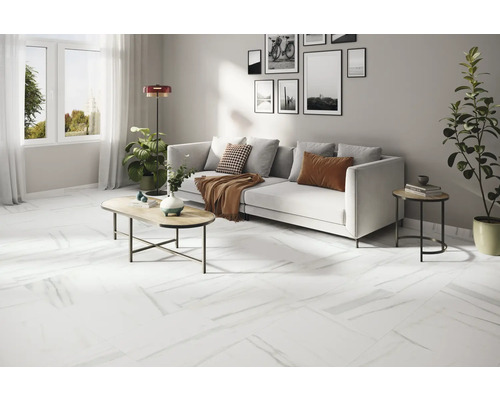 Svetlá obývacia izba s bielou pohovkou, konferenčným stolíkom a bielou podlahou s mramorovým vzhľadom.