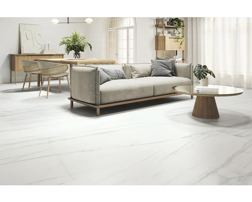 Obývacia izba s pohovkou, stolom a podlahovými dlaždicami s mramorovým vzhľadom.