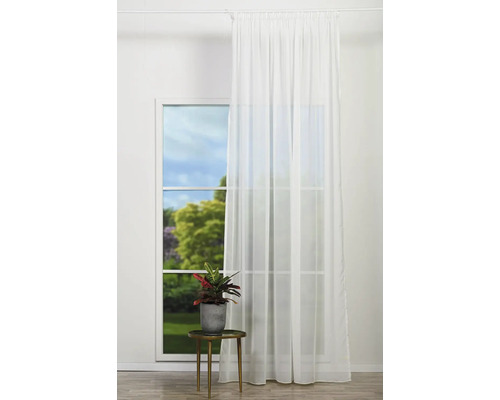 Okno s bielym priesvitným závesom, izbová rastlina na príručnom stolíku