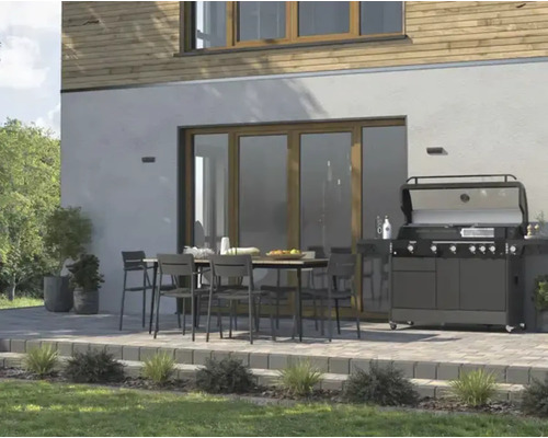 Terasa so záhradným stolom, stoličkami a grilom pred fasádou domu