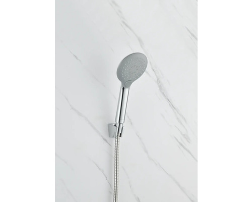 Ručná sprcha s hadicou pripevnená na stene