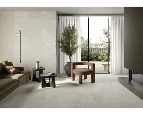 Svetlá obývacia izba s dlažbou, pohovkou, kreslom, izbovou rastlinou a denným svetlom.