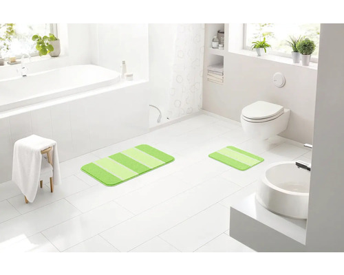 Svetlá kúpeľňa s vaňou, toaletou, umývadlom a dvoma pruhovanými kúpeľňovými predložkami