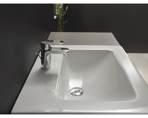 Biele keramické umývadlo s chrómovou batériou na umývadlovej skrinke