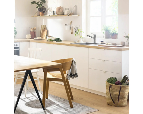 Svetlá kuchyňa s jedálenským stolom, stoličkami a kuchynským náčiním