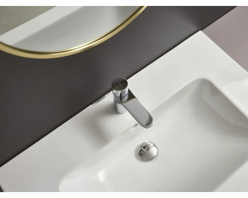 Fotografia bieleho umývadla s chrómovou vodovodnou batériou.