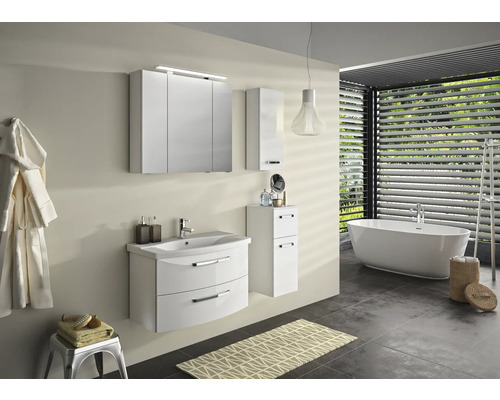 Moderná kúpeľňa s umývadlom, zrkadlovou skriňou, vysokou skriňou a vaňou pod oknom so žalúziami.