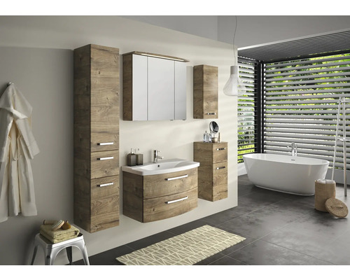 Kúpeľňa s umývadlom, zrkadlovou skrinkou a vysokou skrinkou vo vzhľade dreva a tiež vaňou a držiakom na uteráky.