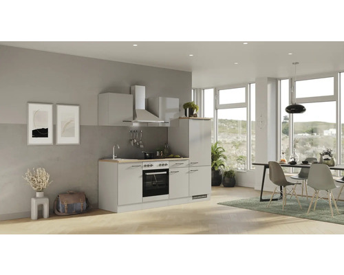 Svetlá kuchyňa s hornými a dolnými skrinkami, digestorom a elektrickými spotrebičmi v modernom obývacom priestore.