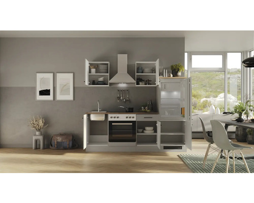 Kompletná kuchynská linka s drezom, sporákom, digestorom, chladničkou a hornými skrinkami v svetlom a usporiadanom priestore.