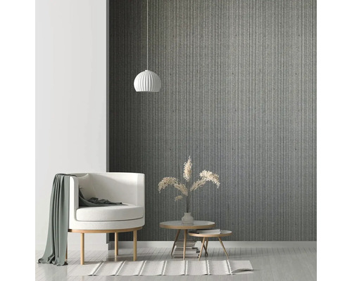 Obývacia izba s kreslom, príručnými stolíkmi a závesným svietidlom pred vzorovanou stenou