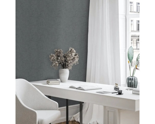 Scéna so sivým pozadím steny, bielym písacím stolom, bielou stoličkou a dekoratívnymi prvkami