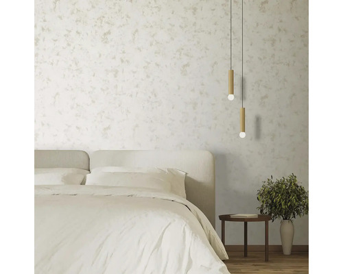 Spálňa s posteľou, nočným stolíkom, izbovou rastlinou a závesnými svetlami pred štruktúrovanou stenou