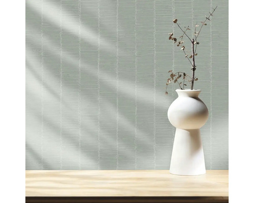 Tapeta s vodorovným vzorom čiar a váza s ozdobnou vetvou na stole