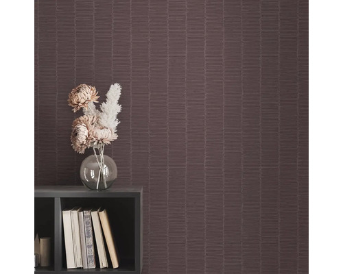 Detailný pohľad na štruktúrovanú tapetu s geometrickým vzorom, kombinovanú s policou, knihami a vázou s kvetinami.