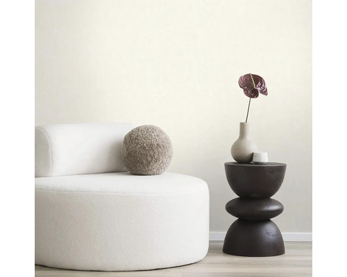 Ukážka usporiadania s kreslom, odkladacím stolíkom a dekoráciou pre štýlové bývanie.