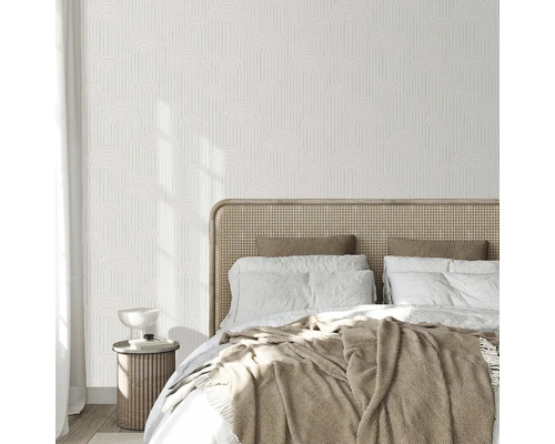 Svetlá spálňa so vzorovanou tapetou, posteľou a nočným stolíkom